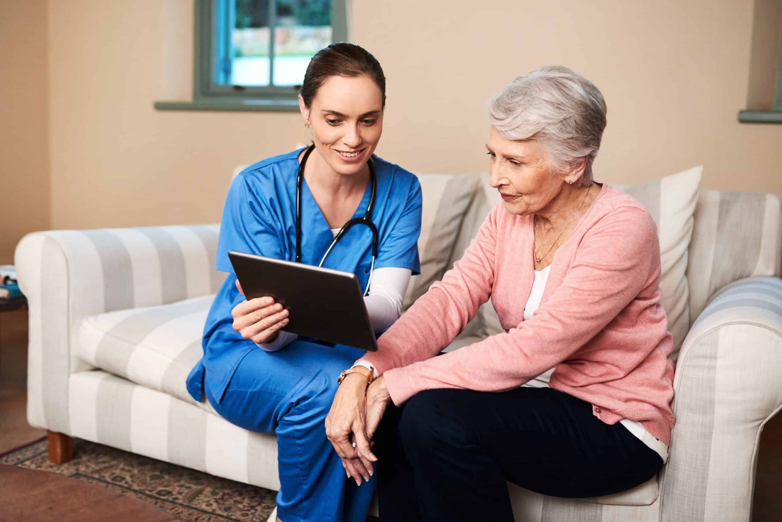 Shot of a female nurse showing her senior patient something on a digital tablet.